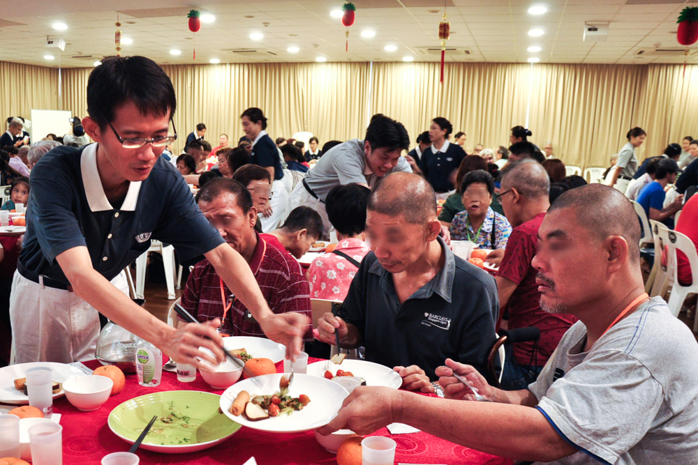 Table leaders serving food to the aid beneficiaries. (Photo by Peter Andrew)