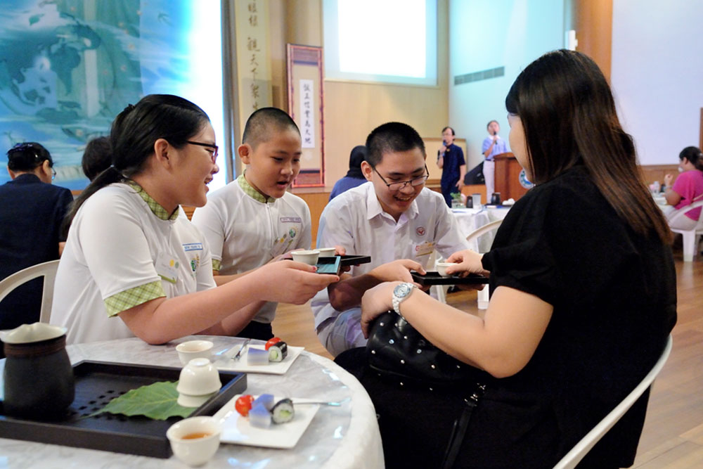 A simple and yet heartwarming tea ceremony allows the student beneficiaries to express their gratitude to their parents by serving tea to the latter. (Photo by Tim Wong) 