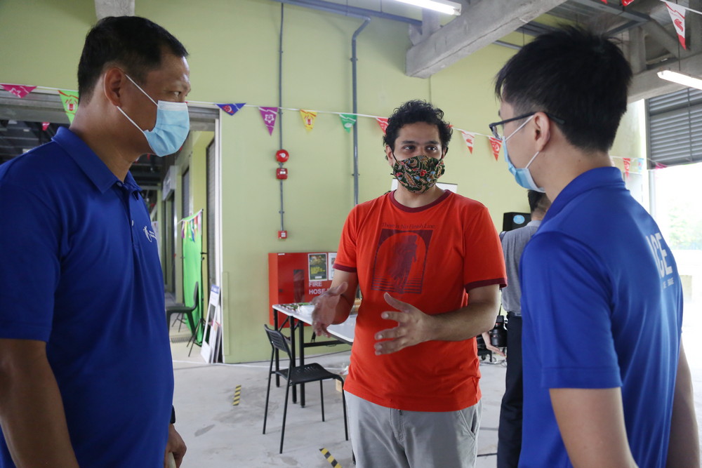 Co-organiser Mr Abhishek Bajaj (in orange) speaking to some MOM officers during the event. (Photo by Alice Toh)